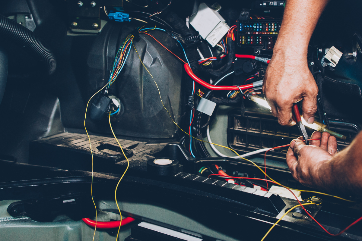 auto electrical repair service in boca raton, fl by boca auto fix. image showing a technician working on complex car wiring and electrical components, highlighting the importance of expert diagnostics and professional repairs for ensuring vehicle safety and reliability.