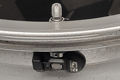 close-up of a tpms sensor mounted on a rim.