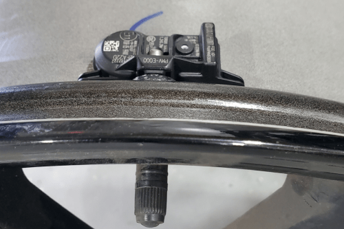 tpms sensor properly installed on a directional tire rim.