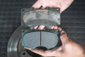 brake pad replacement, auto repair in Boca Raton, FL at Boca Auto Fix. Image of a technician comparing a worn-out brake pad with a new one.