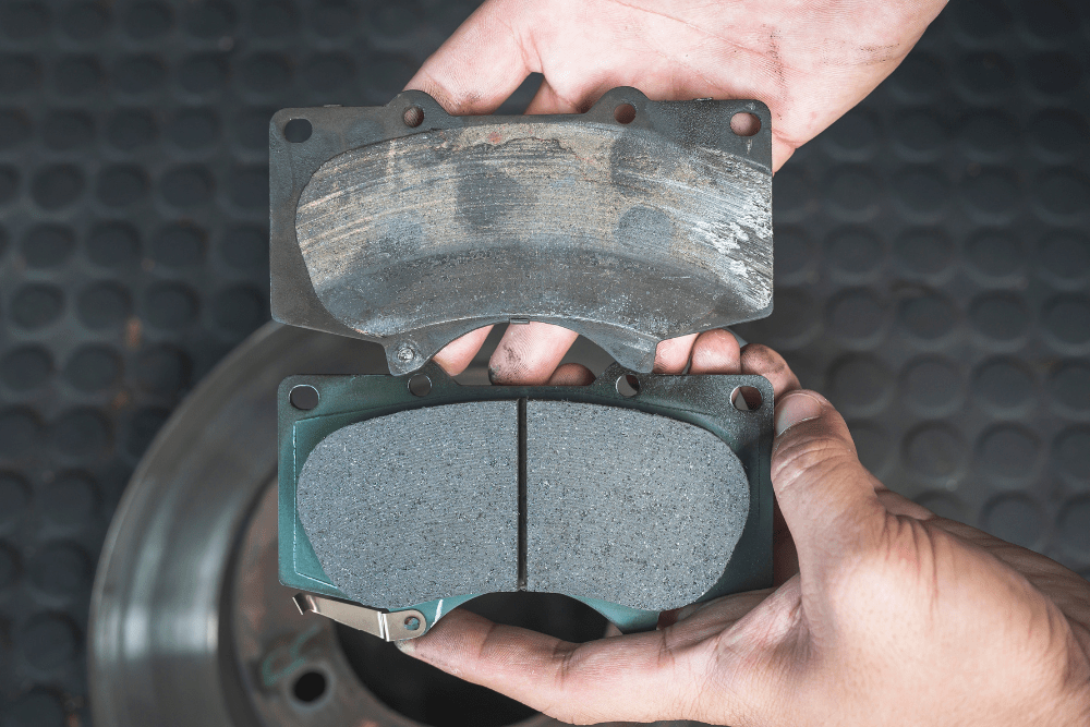 brake pad replacement, auto repair in boca raton, fl at boca auto fix. image of a technician comparing a worn-out brake pad with a new one.