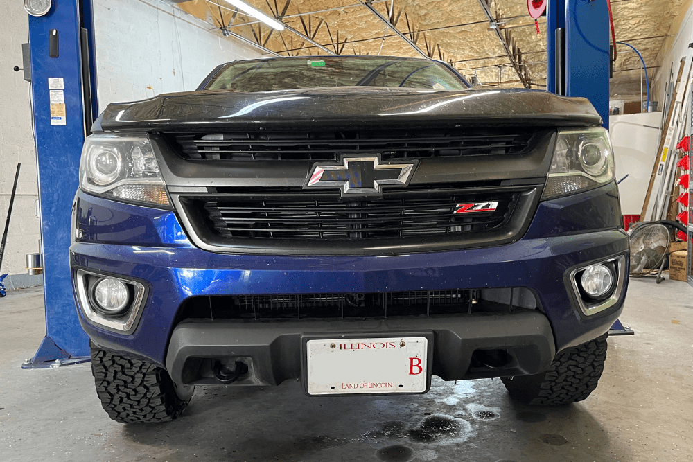 chevrolet auto repair, auto repair in Boca Raton, FL at Boca Auto Fix. A front view image of a blue Chevrolet vehicle inside an auto repair shop.