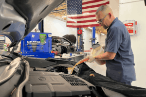 Doug Delucca performing car maintenance on a Subaru vehicle inside Boca Auto Fix's auto repair shop in Boca Raton, FL.