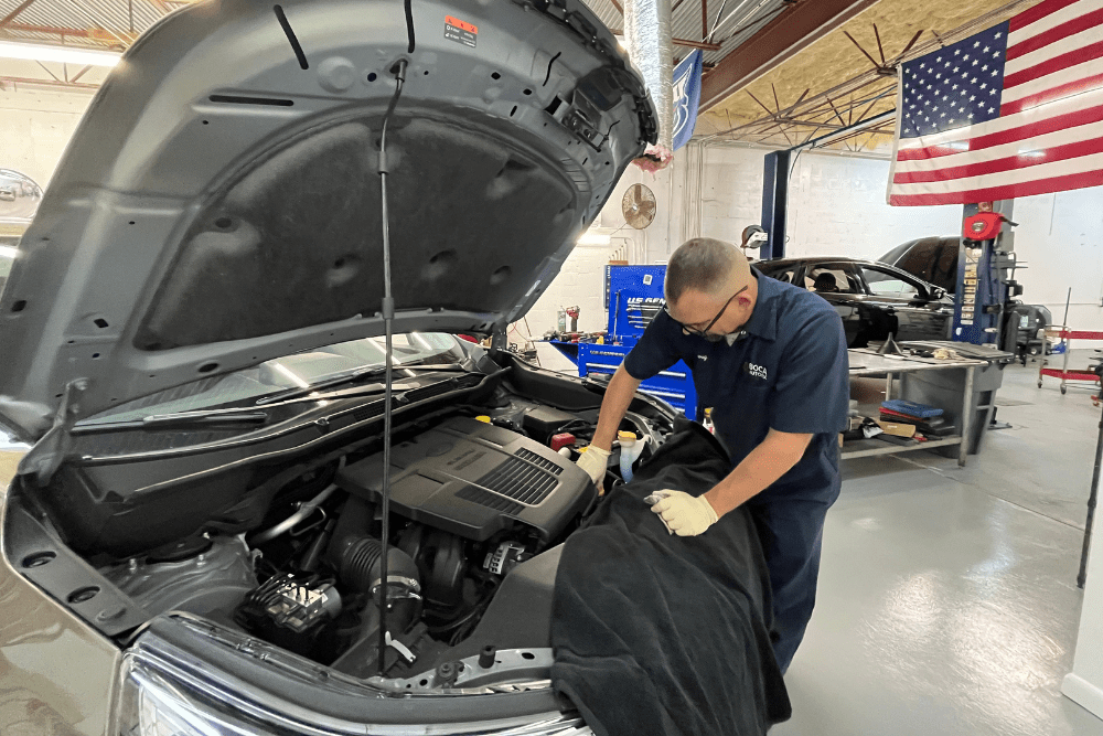 Common Engine Oil Leak Questions Answered by Your Boca Raton Auto Repair Experts - Boca Auto Fix Engine oil leak, auto repairin Boca Raton, FL by Boca Auto Fix. Image of Doug DeLucca performing maintenance under the hood, ensuring optimal vehicle performance.