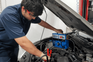 Car maintenance, auto repair in Boca Raton, FL by Boca Auto Fix. Image of a technician using a load tester on a vehicle battery under the hood. Highlighting Boca Auto Fix’s commitment to dependable starting power and reliable electrical performance.