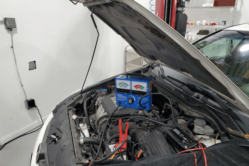 Auto electrical repair in Boca Raton, FL by Boca Auto Fix. Image of a vehicle with the hood open while diagnostic testing equipment checks the electrical system and battery, highlighting professional troubleshooting and reliable vehicle diagnostics.