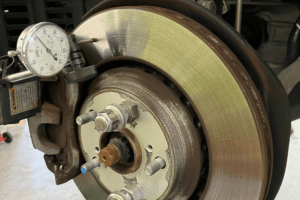 Brake repair in Boca Raton, FL by Boca Auto Fix. Image of a brake rotor with a dial indicator measuring runout for precision diagnostics. Highlighting accurate braking performance, reduced vibration, and maximum driver safety.