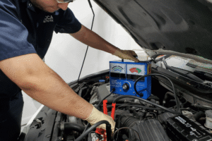 Car battery check, auto repair in Boca Raton, FL at Boca Auto Fix. Image of a technician using a load tester on a vehicle battery, emphasizing accurate testing, reliable starting power, and preventing unexpected breakdowns.
