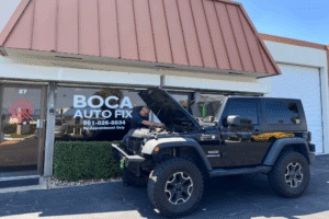 Car inspection, auto repair in Boca Raton, FL, at Boca Auto Fix. Image of Doug DeLucca inspecting a Jeep Wrangler receiving a pre-trip vehicle inspection outside Boca Auto Fix, highlighting professional maintenance services to prepare vehicles for safe and reliable road travel.