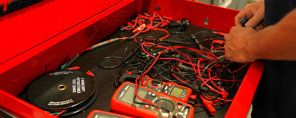 Tools and multimeters organized in a tool chest.